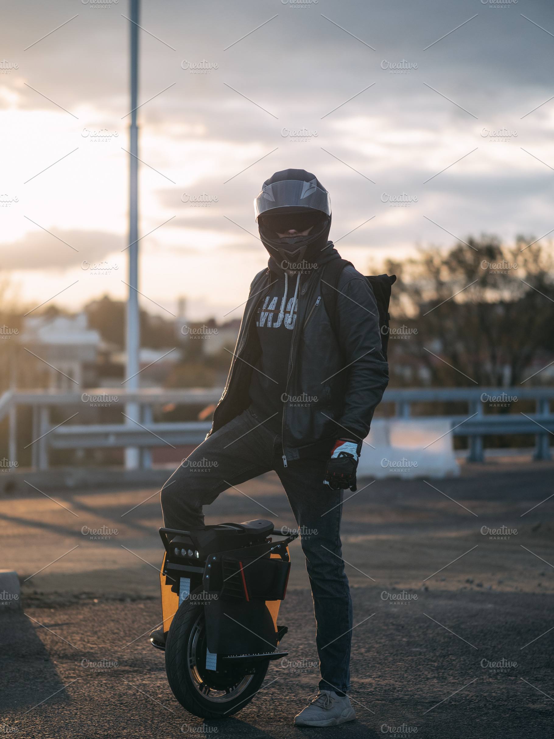young male rider in protective gear with a backpack on an electric unicycle. Dr, a Person Photo by PavelKant