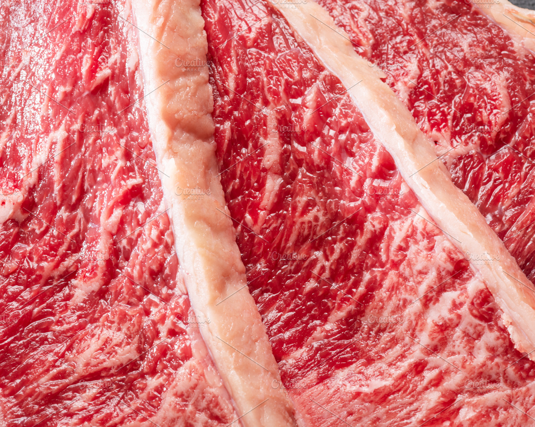 Sliced picanha beef with spices and herbs on a gray stone servin, a Food & Drink Photo by Volff