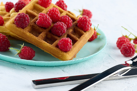 Stack of baked Belgian waffles with ripe red raspberry, a Food & Drink Photo by ndanko
