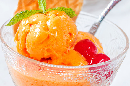 Orange ice cream containing cream, orange, and sorbet, a Food & Drink Photo by Silvia_Pascual