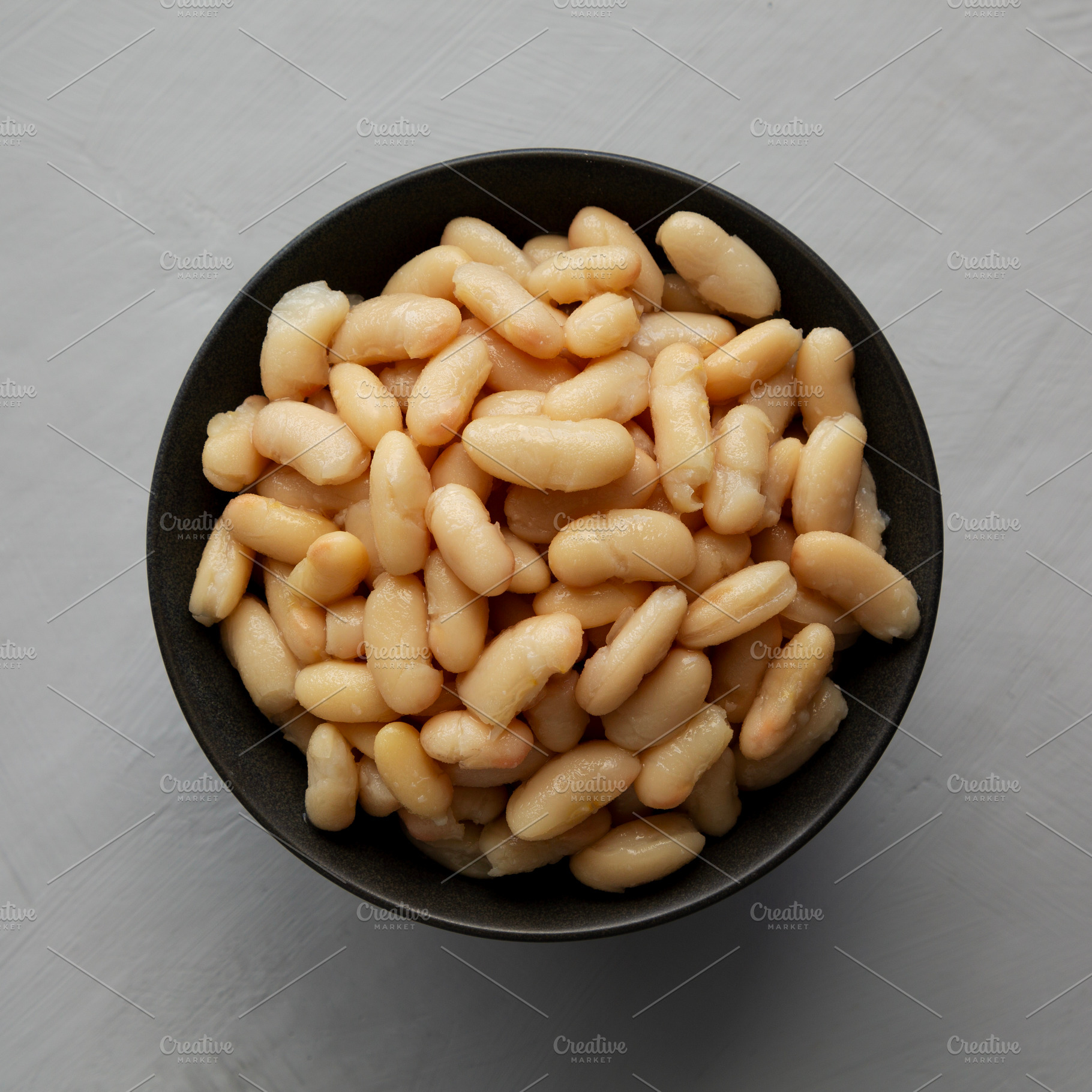 Organic Cannellini Beans in a Bowl, top view. Flat lay, overhead, a Food & Drink Photo by LiudmylaChuhunova