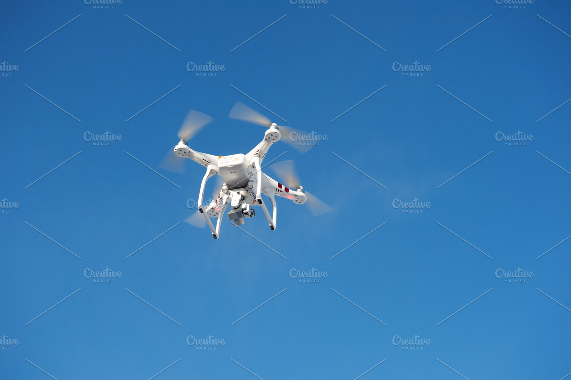 Quadrocopter unmanned camera hovers in bright blue sky containing aircraft, a Technology Photo by MarinaMassel