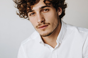 Curly-Haired Man with White Shirt, a Person Photo by Virgo Studio