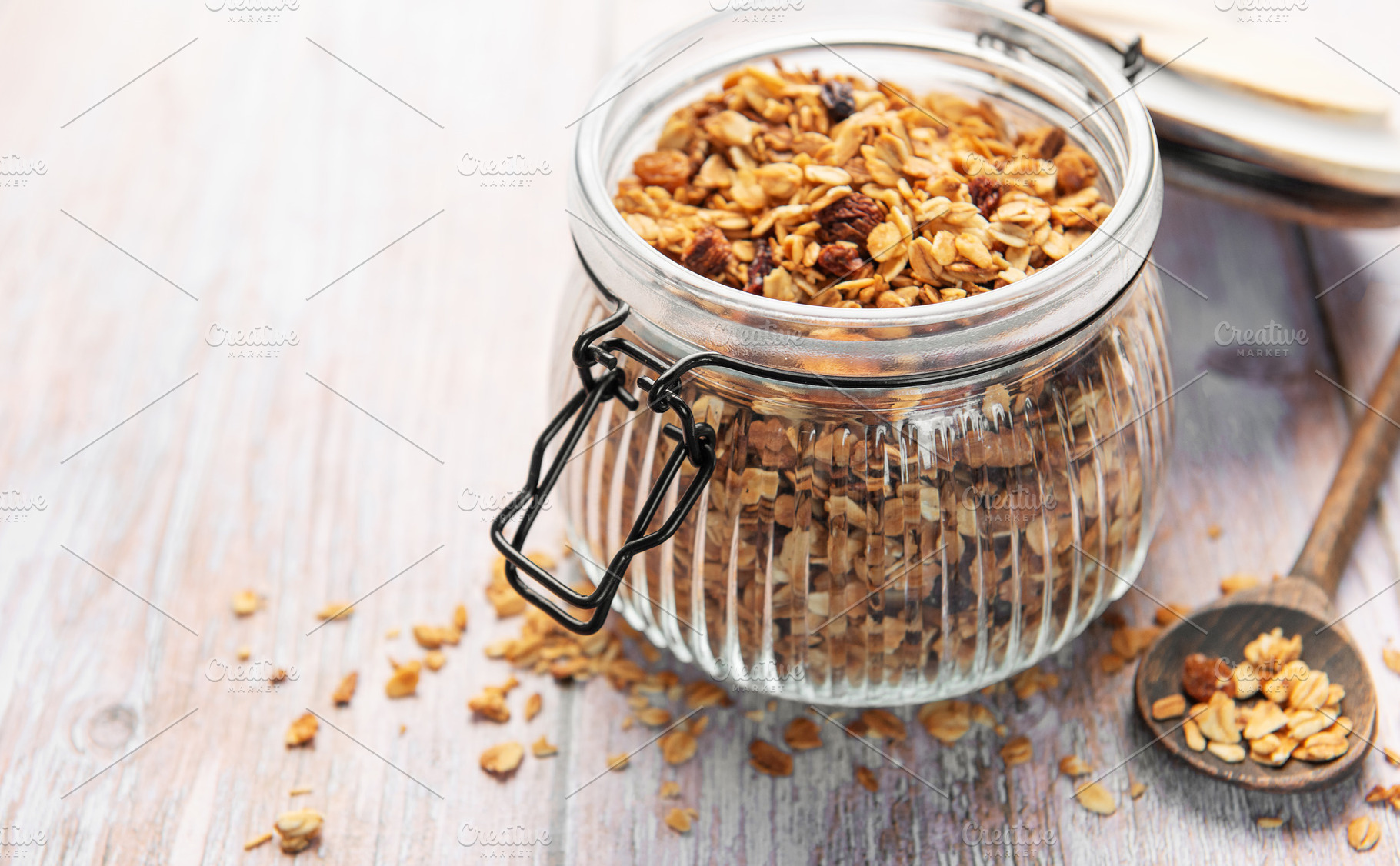 Granola breakfast cereal in glass jar with spoon, a Food & Drink Photo by Olena Rudo