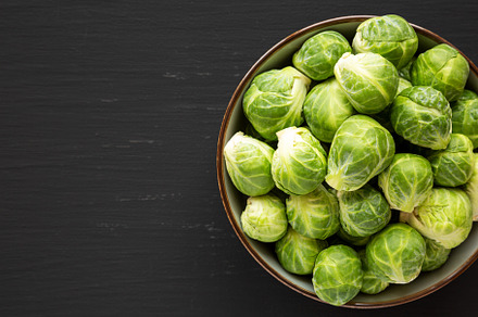Raw Organic Brussel Sprouts in a Bowl on a black background, top, a Food & Drink Photo by LiudmylaChuhunova