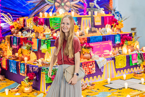 Smiling visitor beside a colorful, a Person Photo by Elizaveta Galitskaya