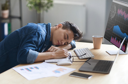 Portrait Of Tired Young Male Employee Sleeping At Work