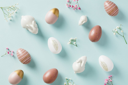 Stylish Easter eggs and decorative bunnies on pastel blue background. Happy Eas