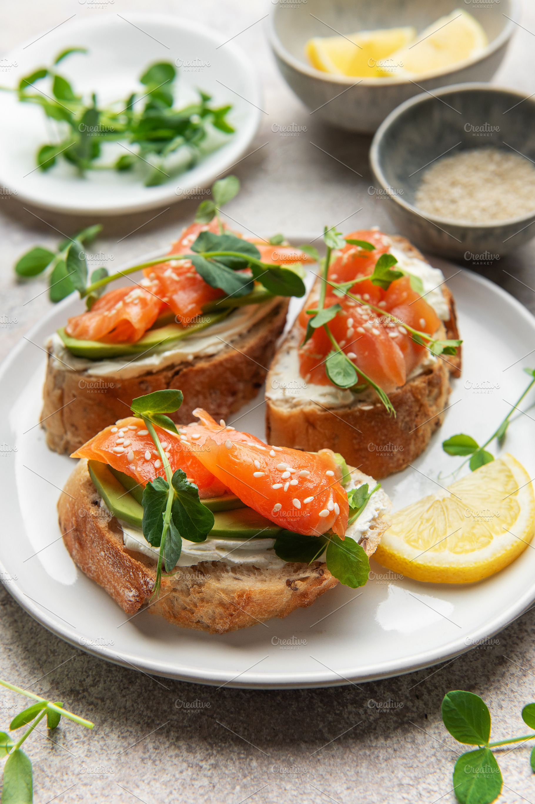 Salmon avocado toasts with microgreens and lemon, a Food & Drink Photo by Olena Rudo