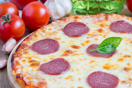 Homemade pepperoni pizza on a wooden board, ready to eat, a Food & Drink Photo by iuliia_n