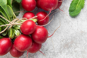 Fresh radishes bunch with green leaves on light background, a Food & Drink Photo by Olena Rudo