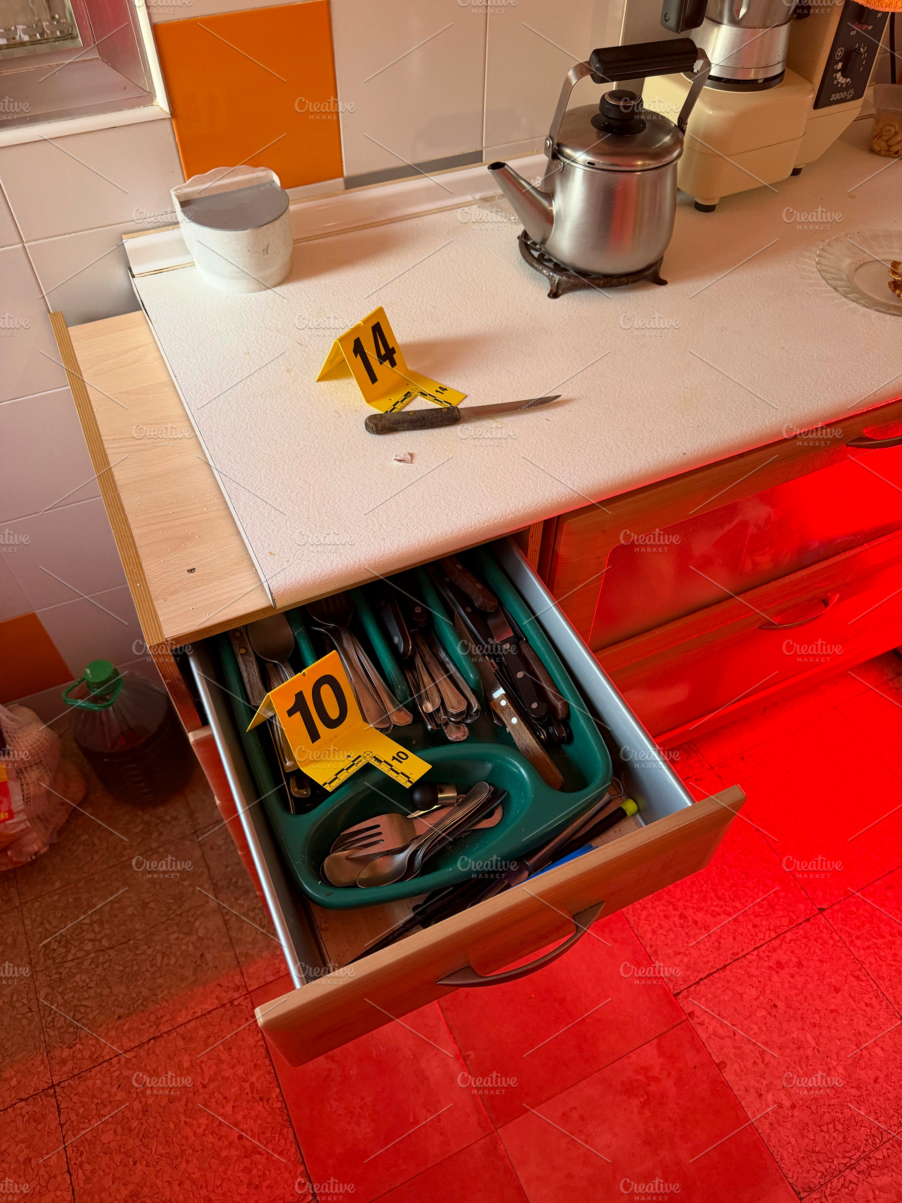 Crime scene investigation with knife and evidence markers in kitchen, an Industrial Photo by karrastock
