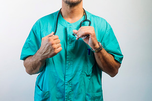 Doctor Adjusting His Stethoscope, a Person Photo by karrastock