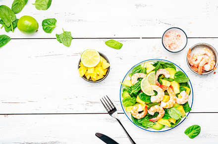 Fresh pineapple salad with shrimps, spinach, avocado and lime on, a Food & Drink Photo by 5PH