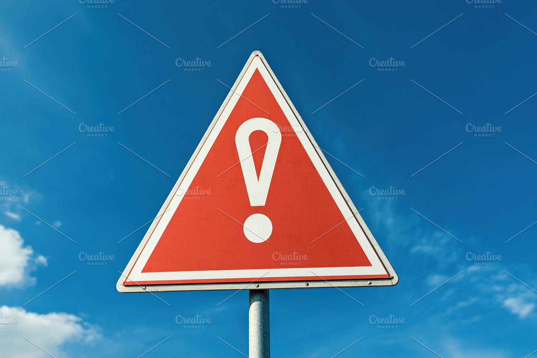A triangular warning sign with an exclamation mark stands prominently against a, an Abstract Photo by AlyaAnd