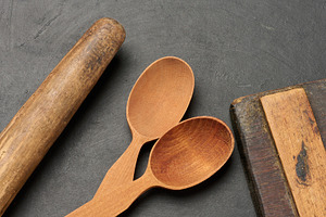 Wooden spoons, cutting board and rolling pin on a dark surface, a Food & Drink Photo by ndanko