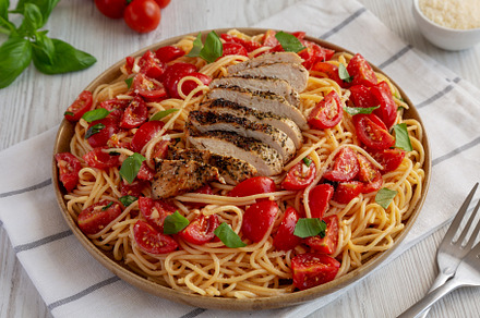 Homemade Bruschetta Chicken Pasta on a Plate, side view., a Food & Drink Photo by LiudmylaChuhunova