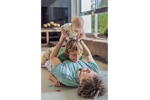 Father, son, and newborn baby lying, a Person Photo by Elizaveta Galitskaya
