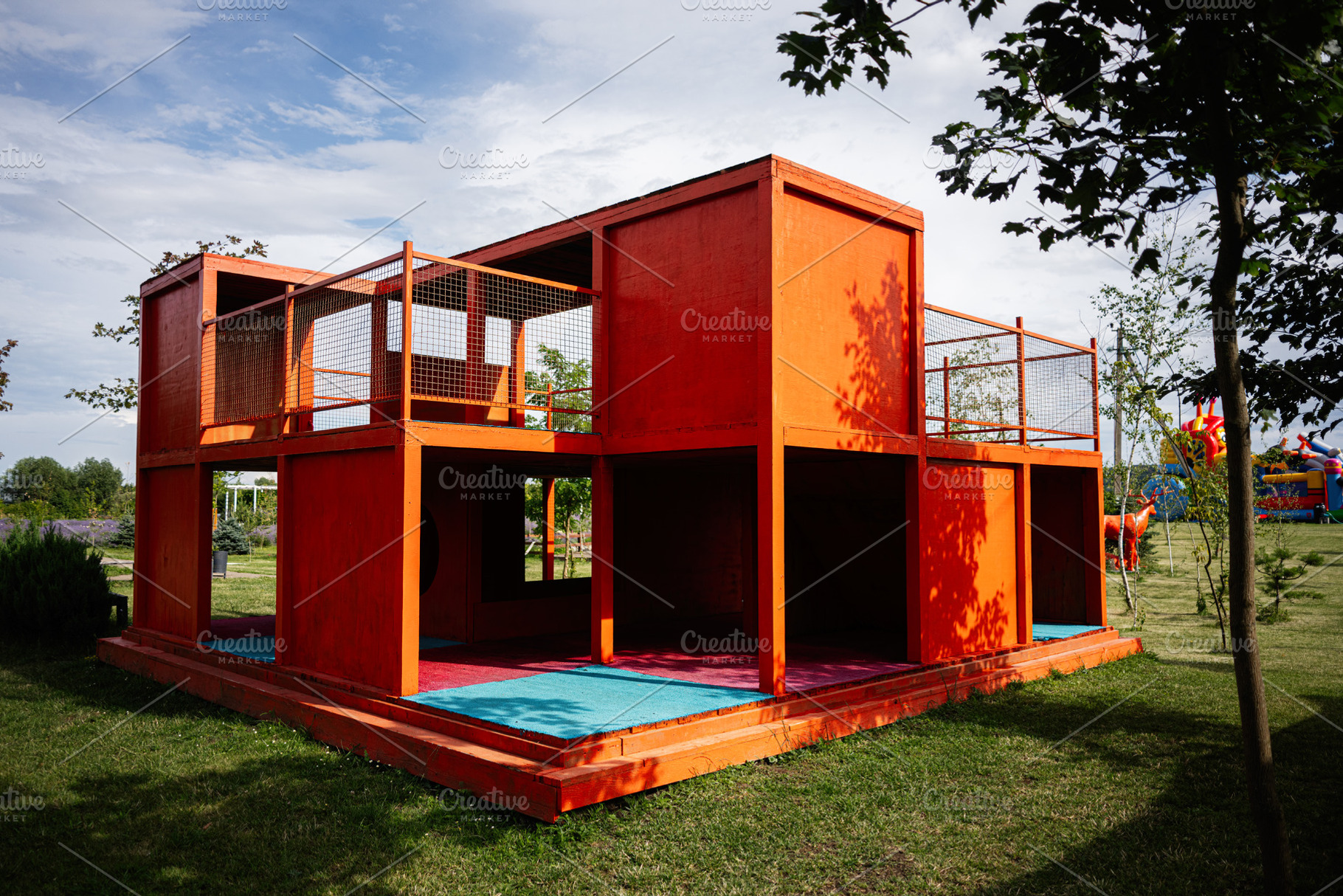 Bright orange playground structure in a park with vibrant colors and greenery., a Photo by AS photostudio
