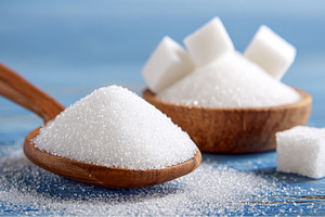 White granulated sugar and sugar cubes on a wooden spoon and in, a Photo by Studio ANNA