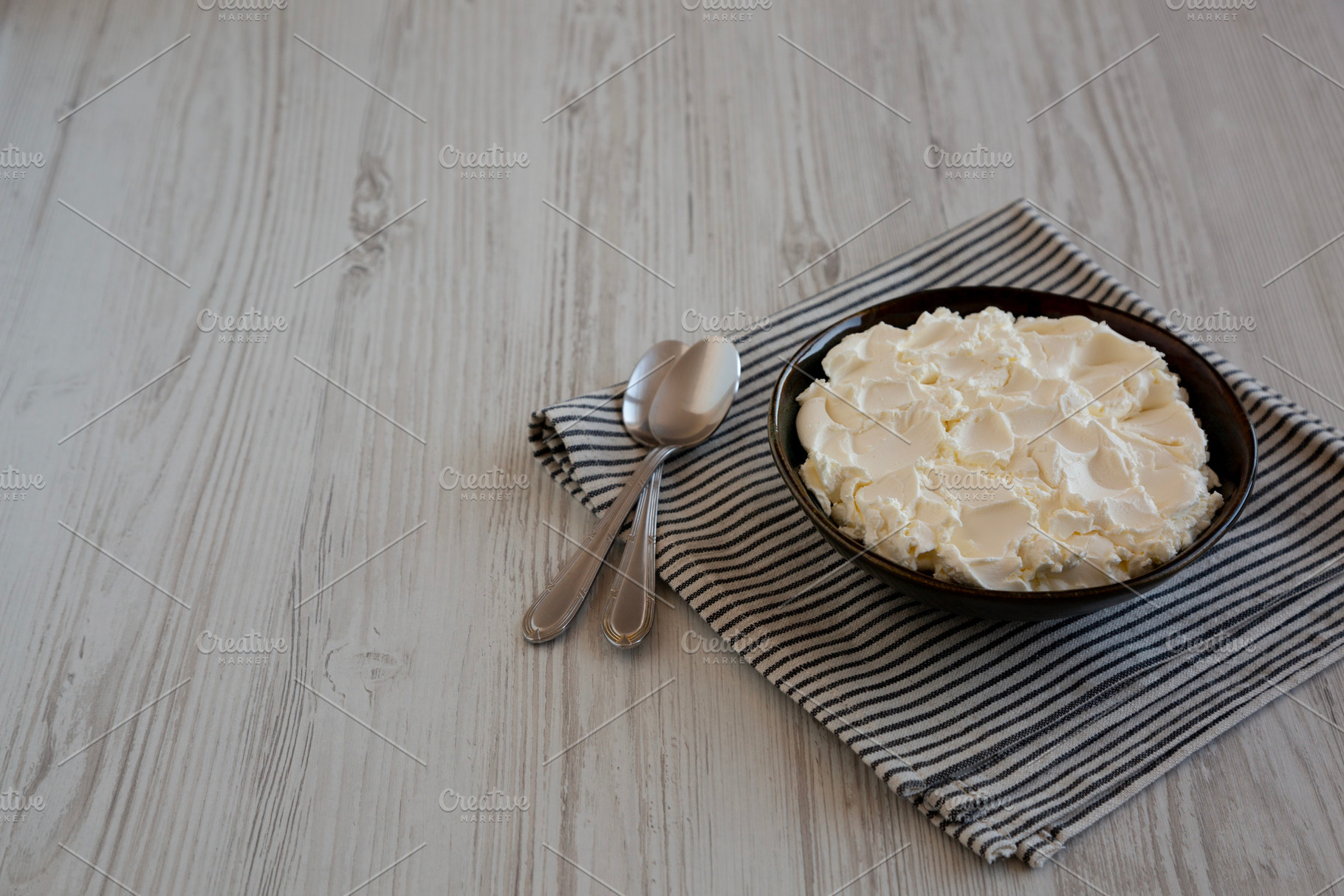 Organic White Mascarpone Cheese in a Bowl, side view. Copy space, a Food & Drink Photo by LiudmylaChuhunova