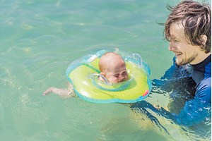 Father and newborn son swimming in, a Person Photo by Elizaveta Galitskaya