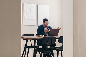 Young businessman speaking during a video conference, a Person Photo by Jacob Lund