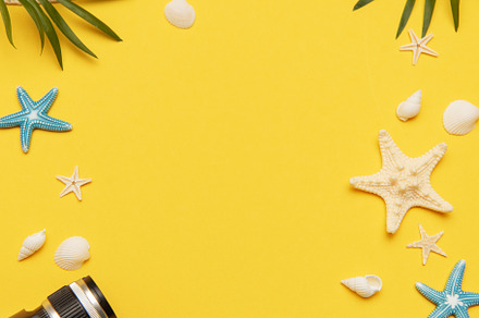 Summer accessories framing vibrant yellow background for travel