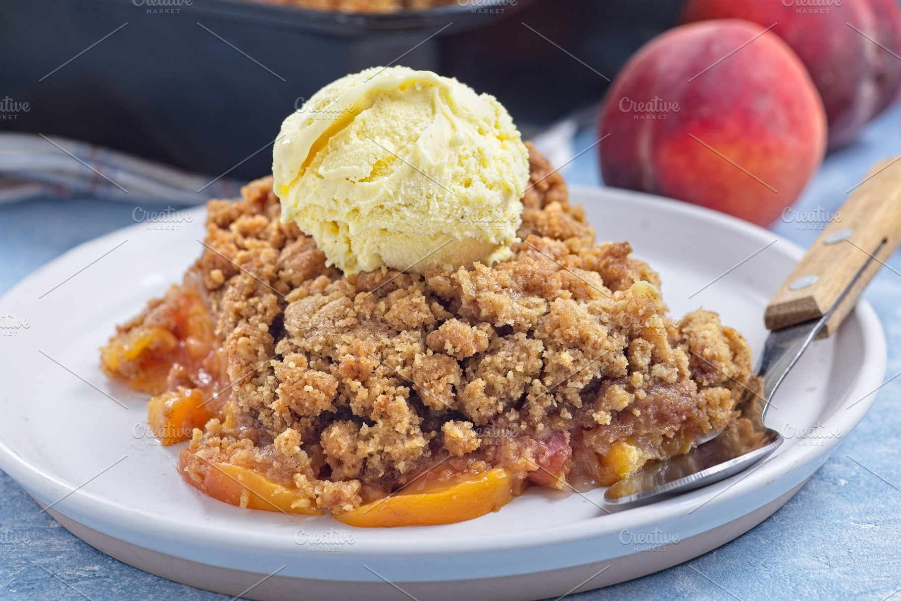 Peach Crisp or cobbler on plate with scoop of vanilla ice cream, horizontal, a Food & Drink Photo by iuliia_n