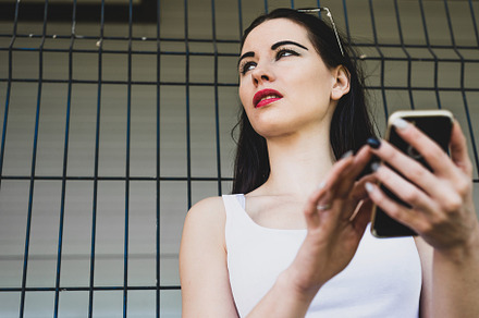 A terrified woman is holding a telep