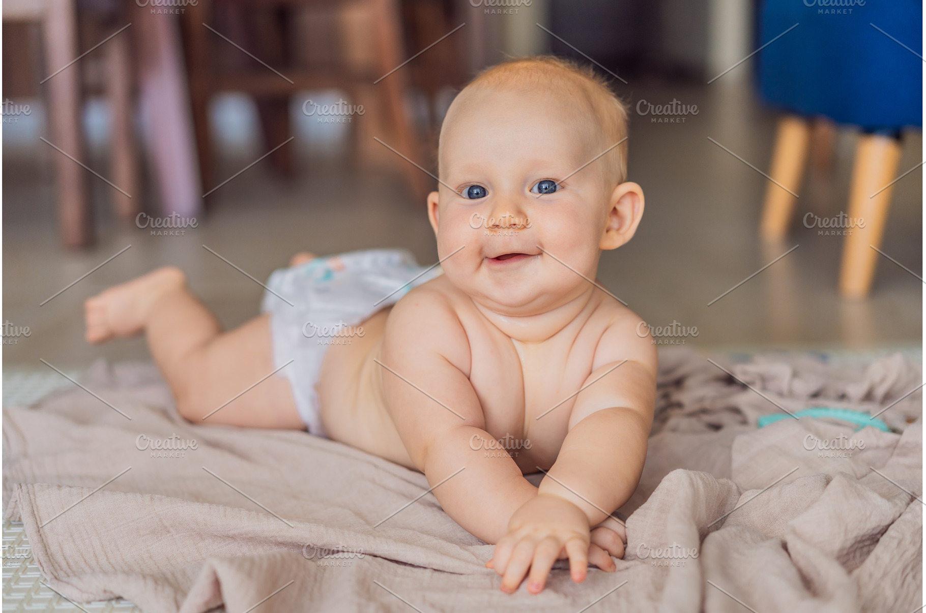 Baby lying on play mat learning to, a Background Photo by Elizaveta Galitskaya