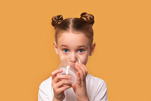 Young girl with brown hair in buns drinks water from a glass, lo, a Person Photo by Ales Munt