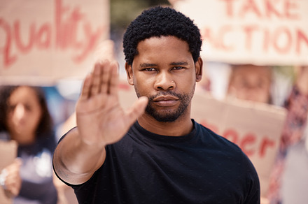 Protest, hand and stop with a black man in a demonstration or rally for human rights and equality. Justice, freedom and politics with a male activist ready to fight racism, violence or discrimination, a Photo by Peopleimages.com