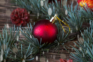 Christmas balls with fir branches lying on a wooden table featuring