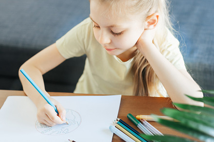 Child girl drawing with colorful pencils, a Person Photo by Olena Rudo