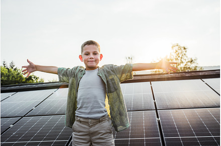 Cute boy standing on roof with solar