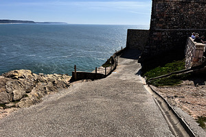 Coastal pathway leading to fort with ocean view in Nazare, Portugal, a Photo by AS photostudio