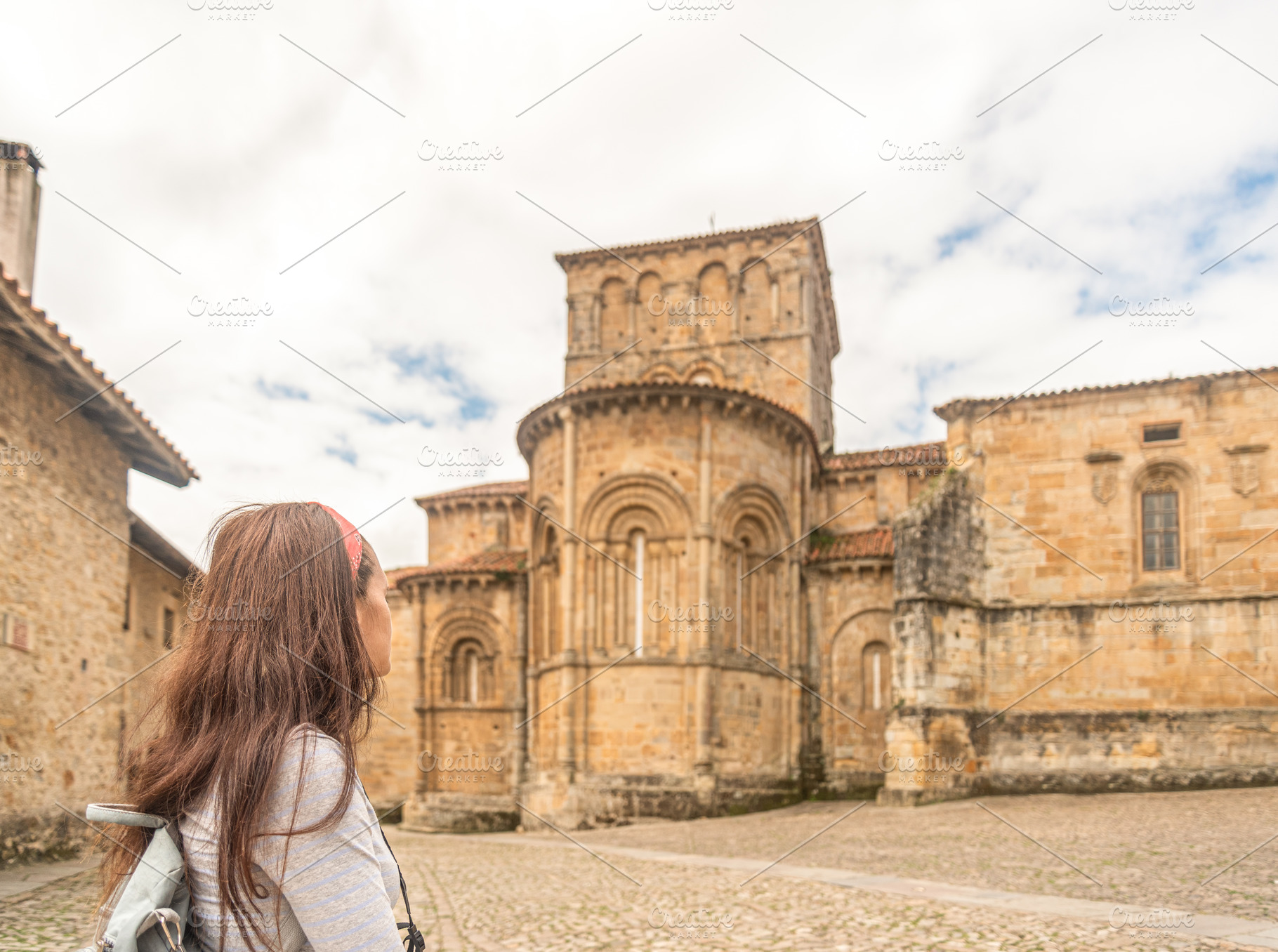 Anonymous woman visiting ancient stone catholic church, a Holiday Photo by Iván Moreno STOCK PHOTO