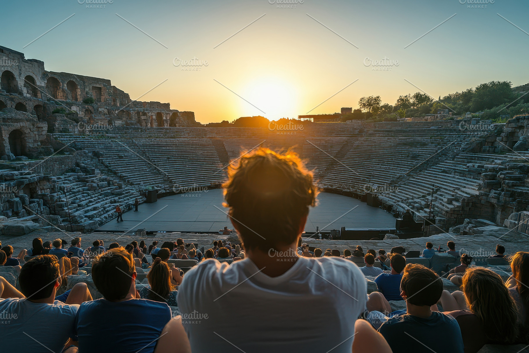 Audience watches sunset over ancient, a Photo by Tanuart