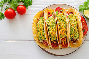 Vegetarian tacos with guacamole, cheese and tomatoes on a plate, a Food & Drink Photo by AlyaAnd