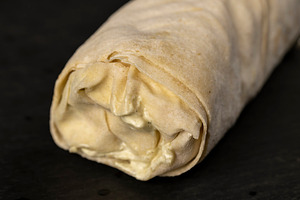 shawarma from thin tortilla with meat with tomatoes and sauce, fast food made f, a Photo by rsoollAI