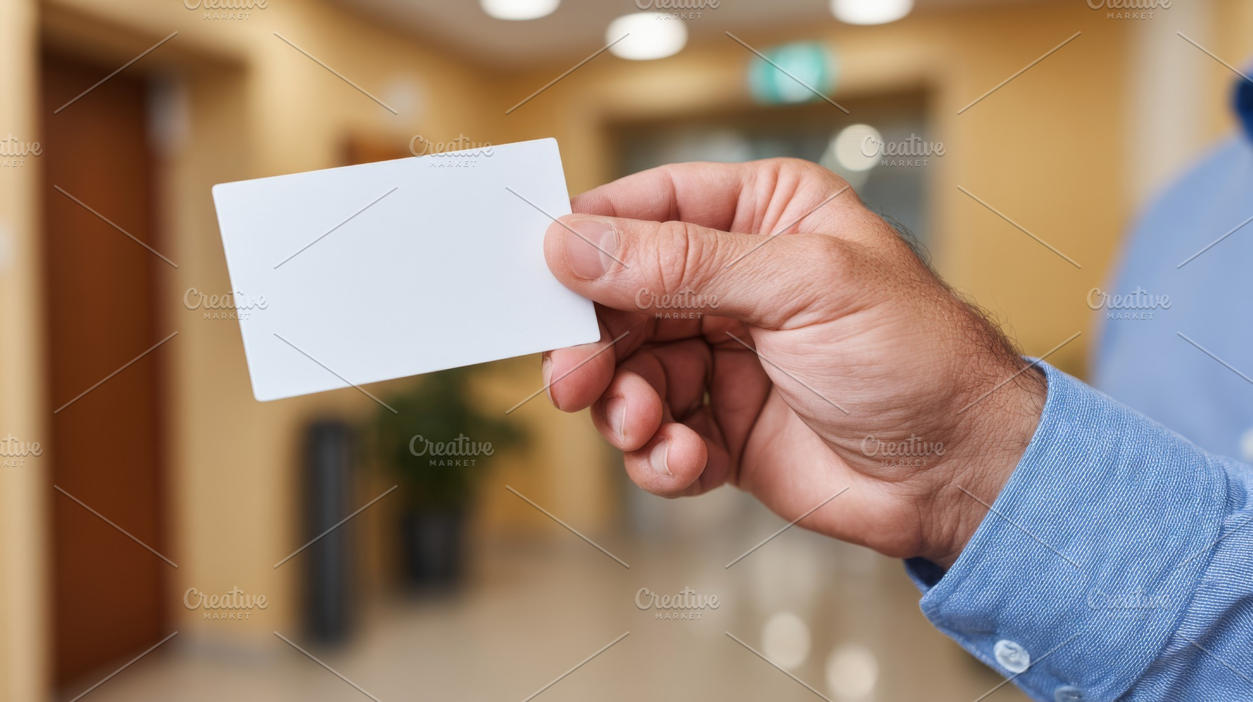 A man holds a blank white card, suggesting identity or access. The indoor setti, a Business Photo by ImageMir