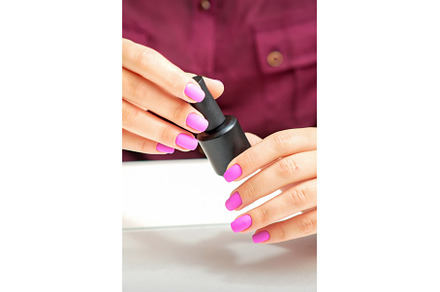 White woman holding nail polish, a Beauty & Fashion Photo by okskukuruza