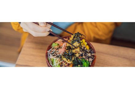 Woman eating Raw Organic Poke Bowl, a Food & Drink Photo by Elizaveta Galitskaya