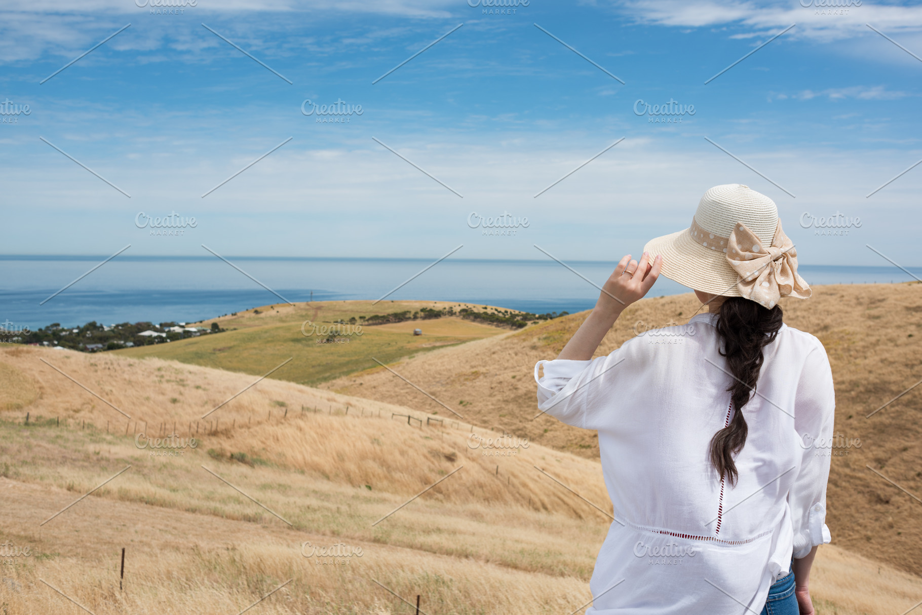 Woman looking at rolling landscape, a Person Photo by EsmeHelit