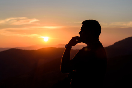 Man with hands on chin stand on the mountain and watching over t, a Person Photo by Byrdyak