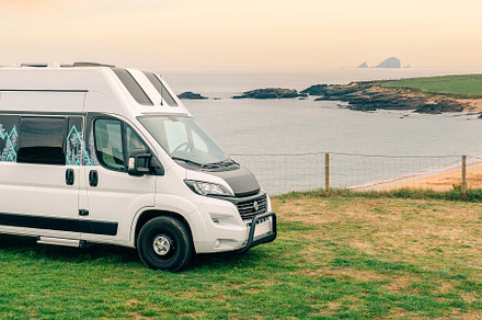 Camper van parked next to beach at summer, a Transportation Photo by davidpereiras