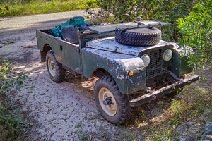 Vintage jeep parked in forest path, a Transportation Photo by DanFLCreativo