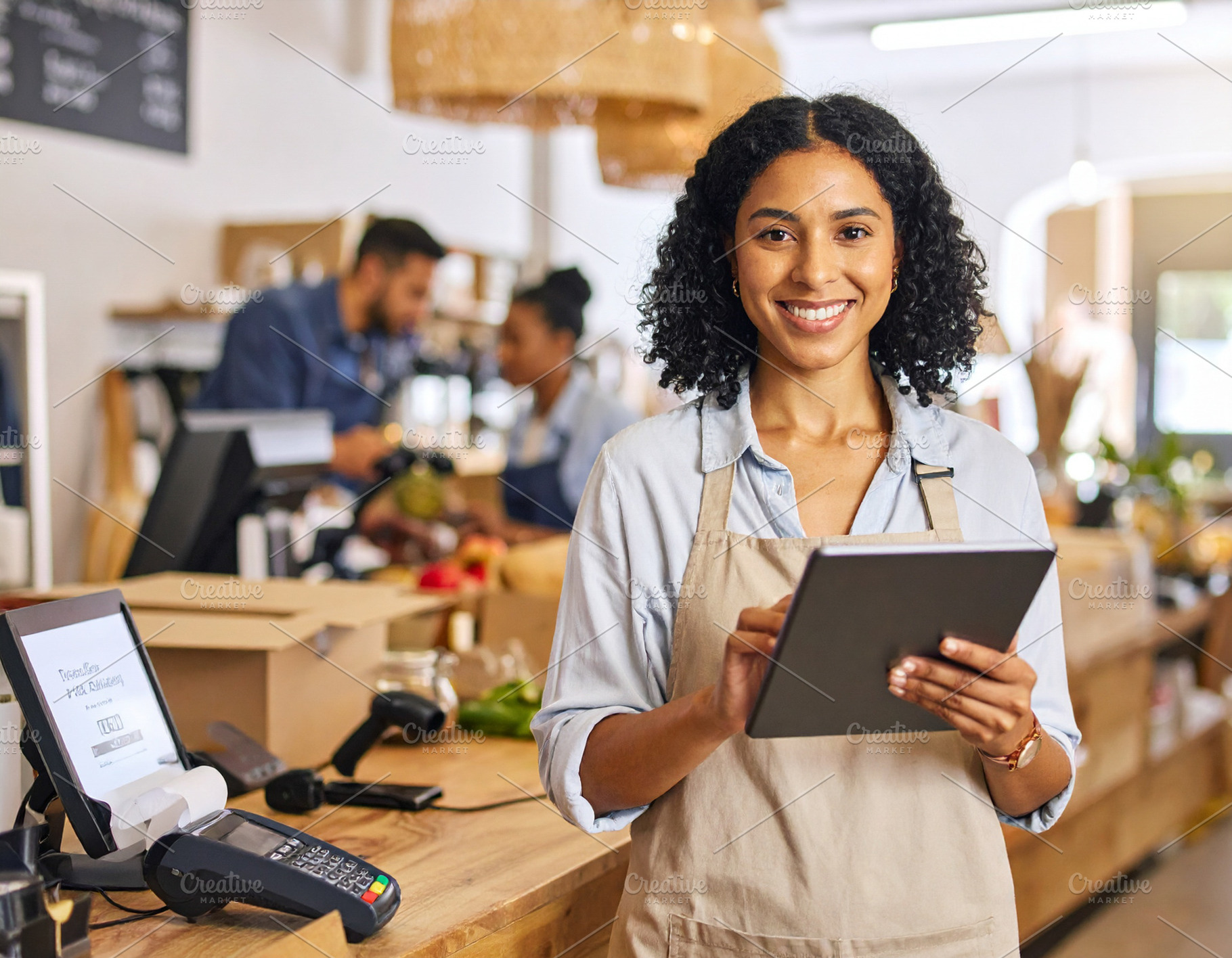 Woman holding tablet while looking at camera at small business e, a Business Photo by DanFLCreativo