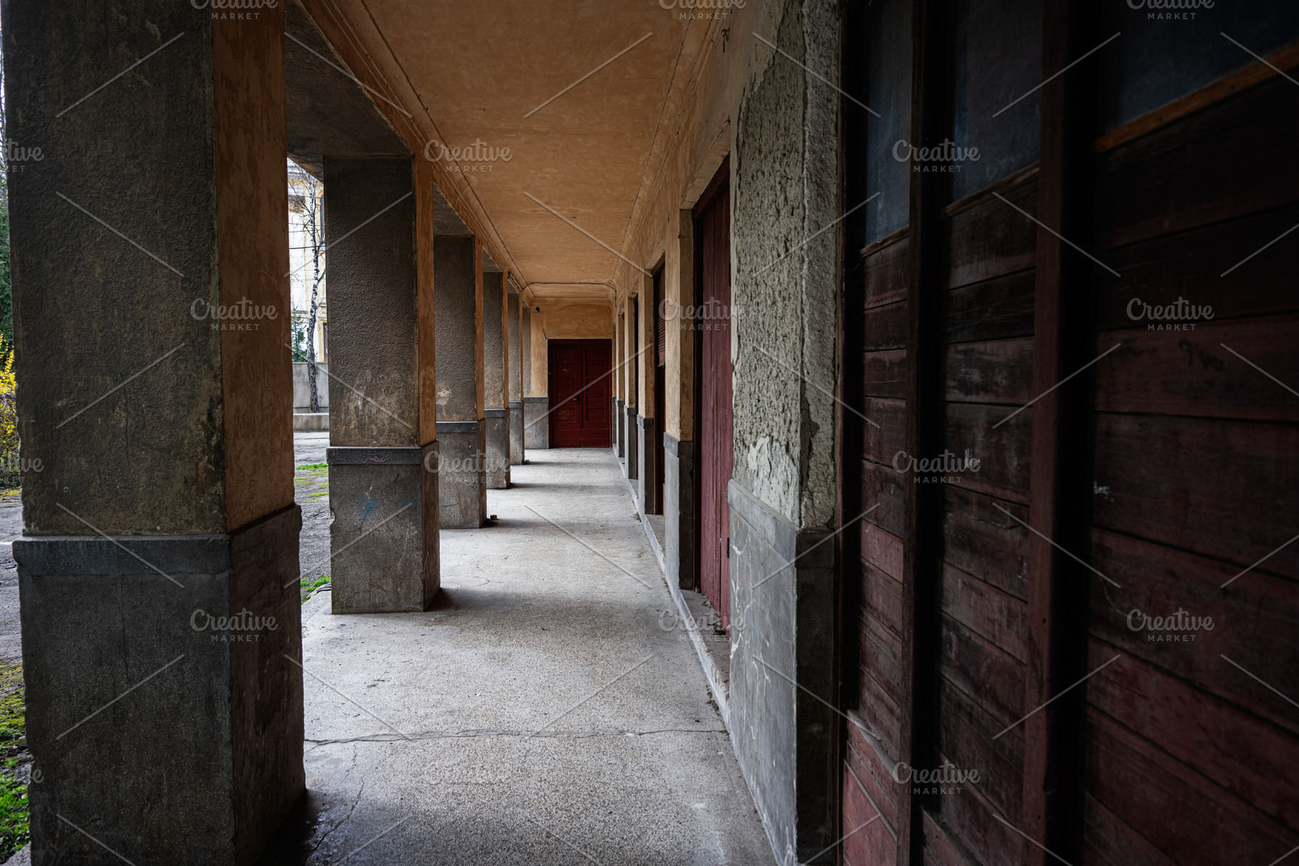 Abandoned corridor with weathered walls and wooden doors in Buchach, Ukraine, a Photo by AS photostudio